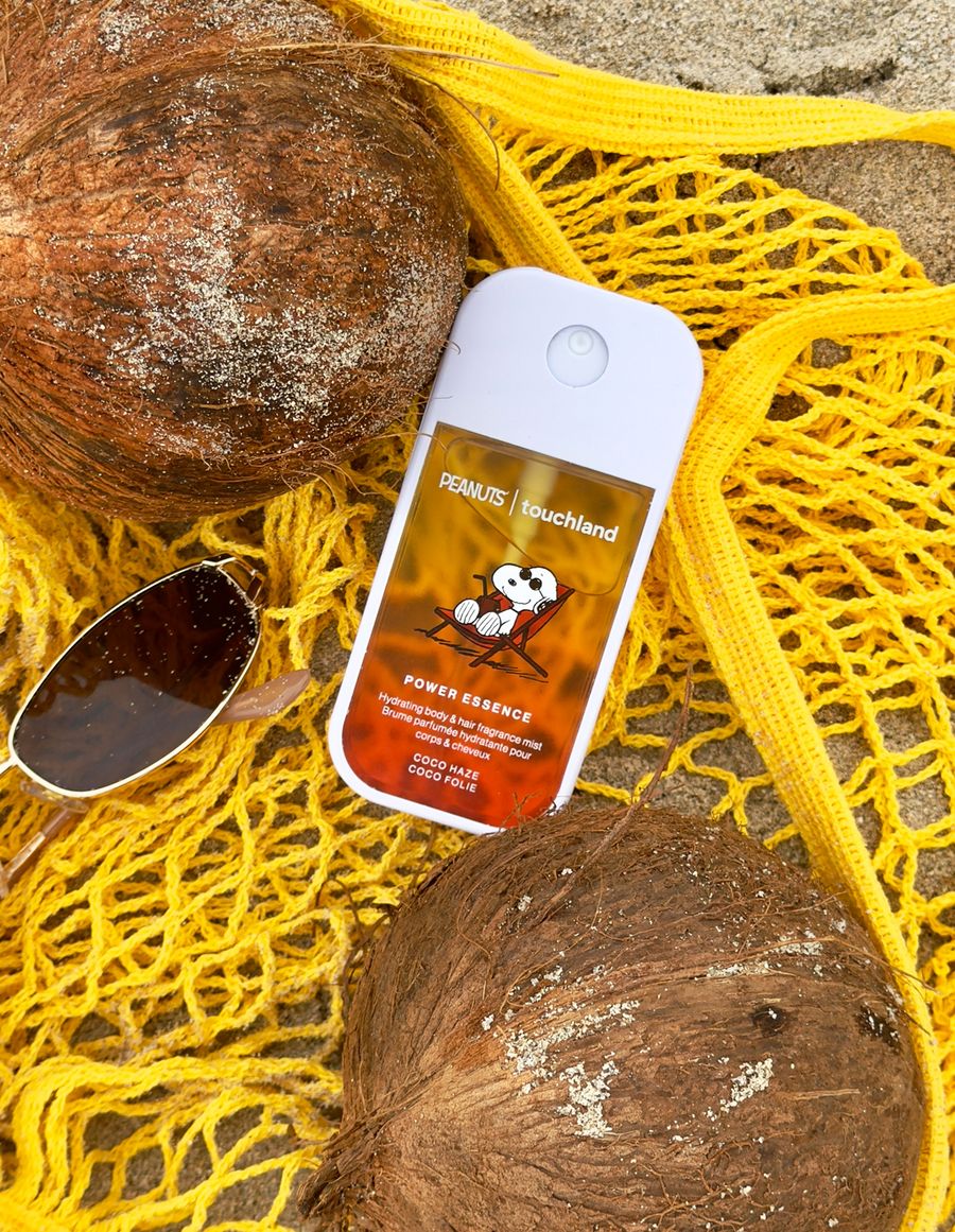 Skincare product with coconuts and sunglasses on a yellow netting background