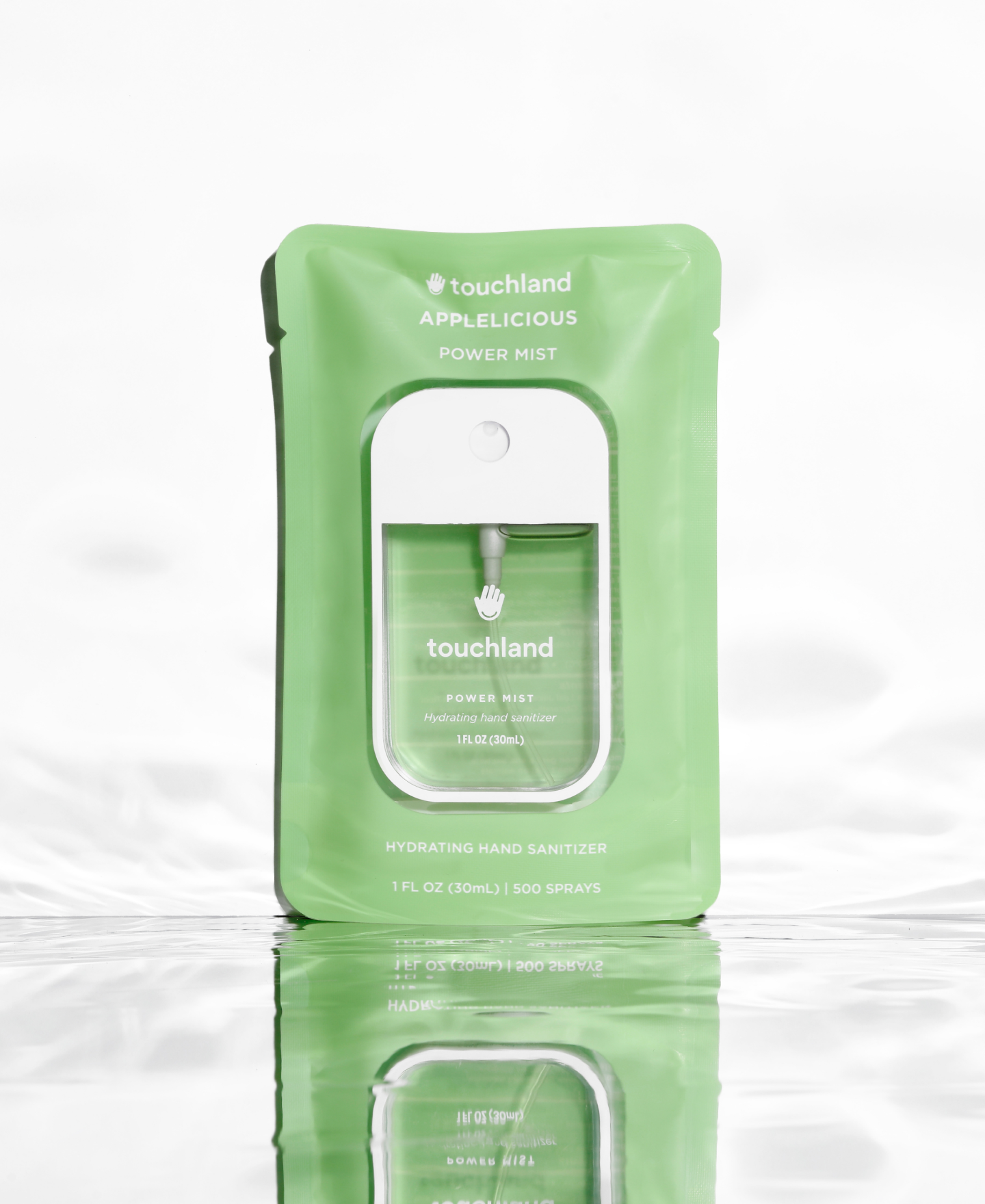 Power Mist hydrating hand sanitizer Applelicious scented inside green packaging standing on a mirror floor with water