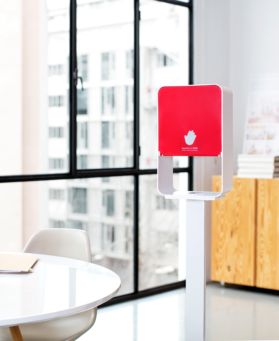 Red kub dispenser in office setting on stand near windows
