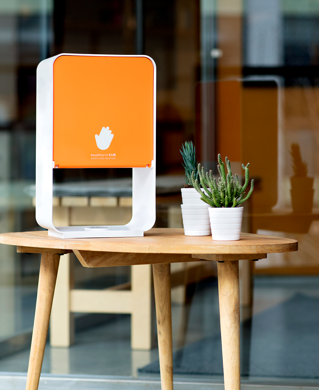 Orange kub dispenser on wooden table outside office next to chair
