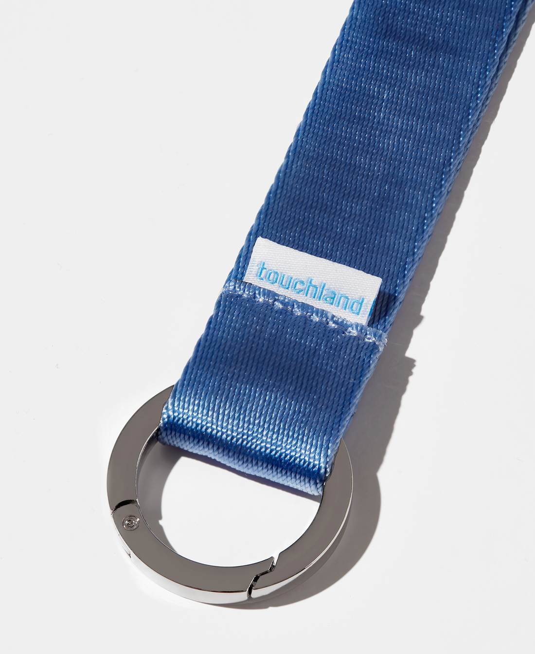 Blue lanyard zoomed in on silver ring on white background