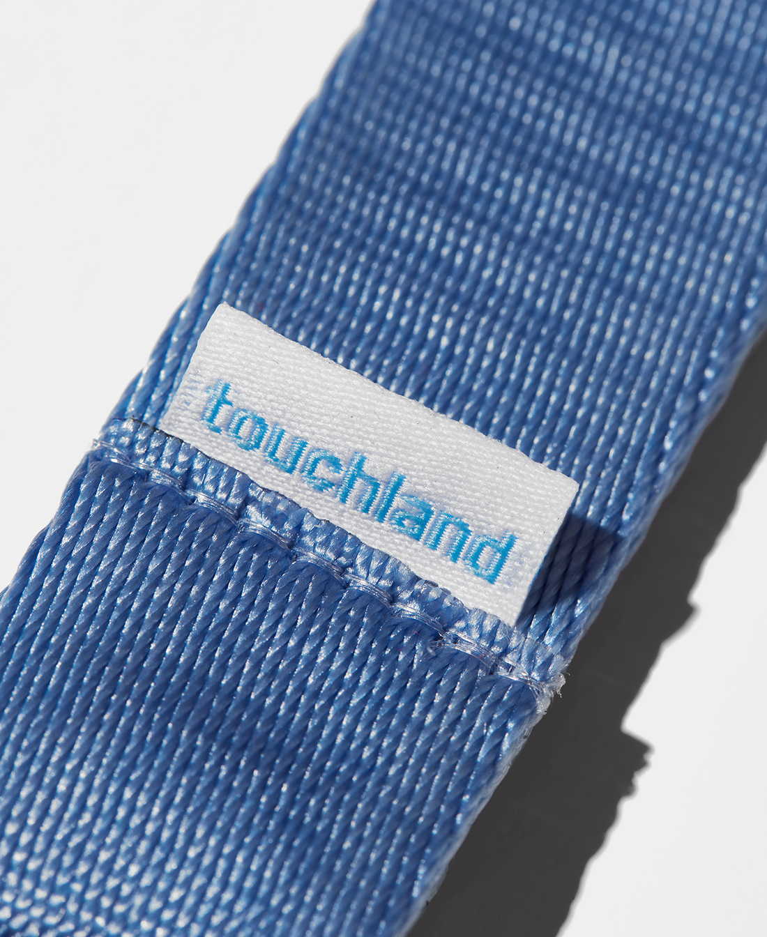 Blue lanyard zoomed in on touchland tag with white background