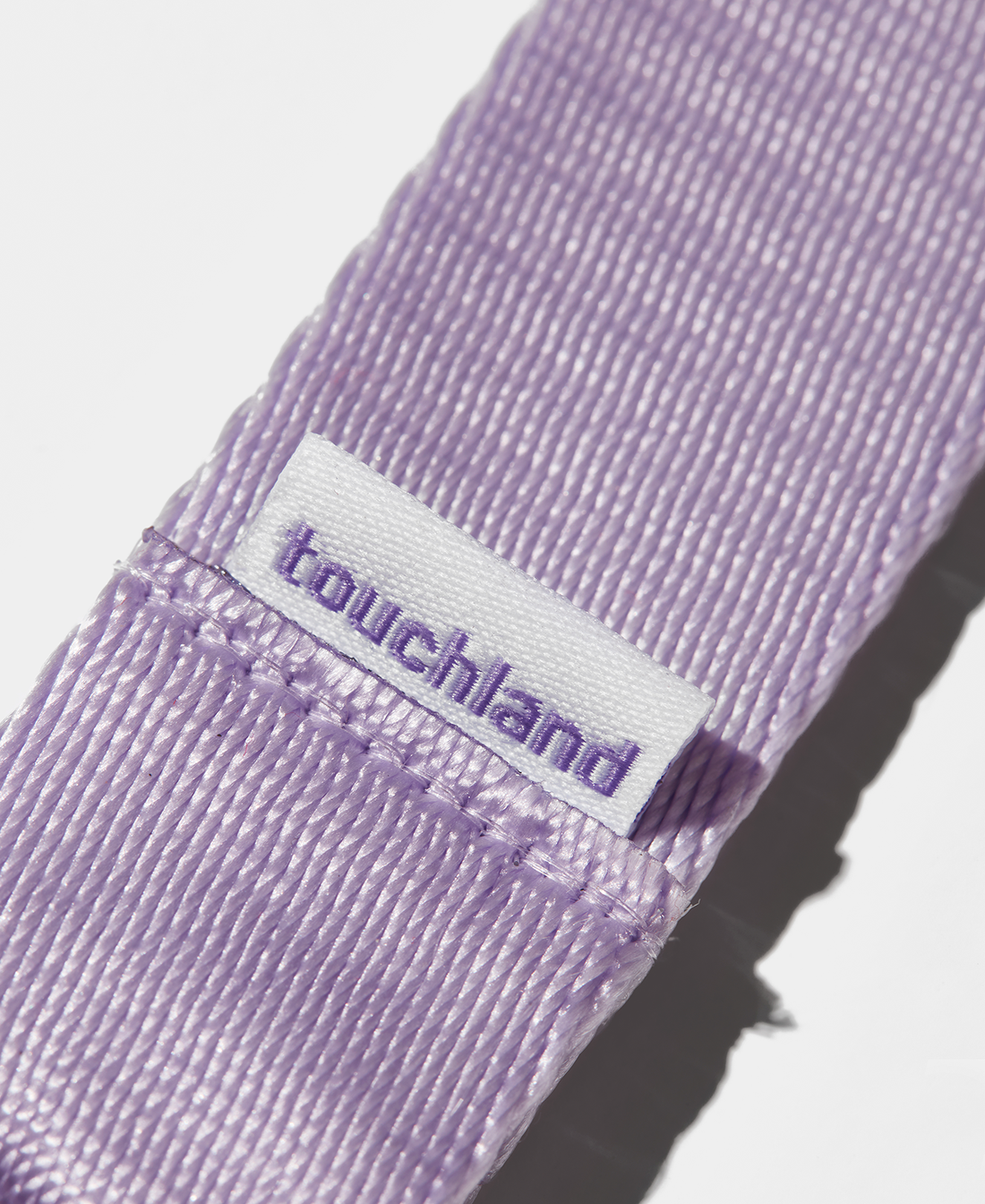 Purple lanyard zoomed in on touchland label on white background