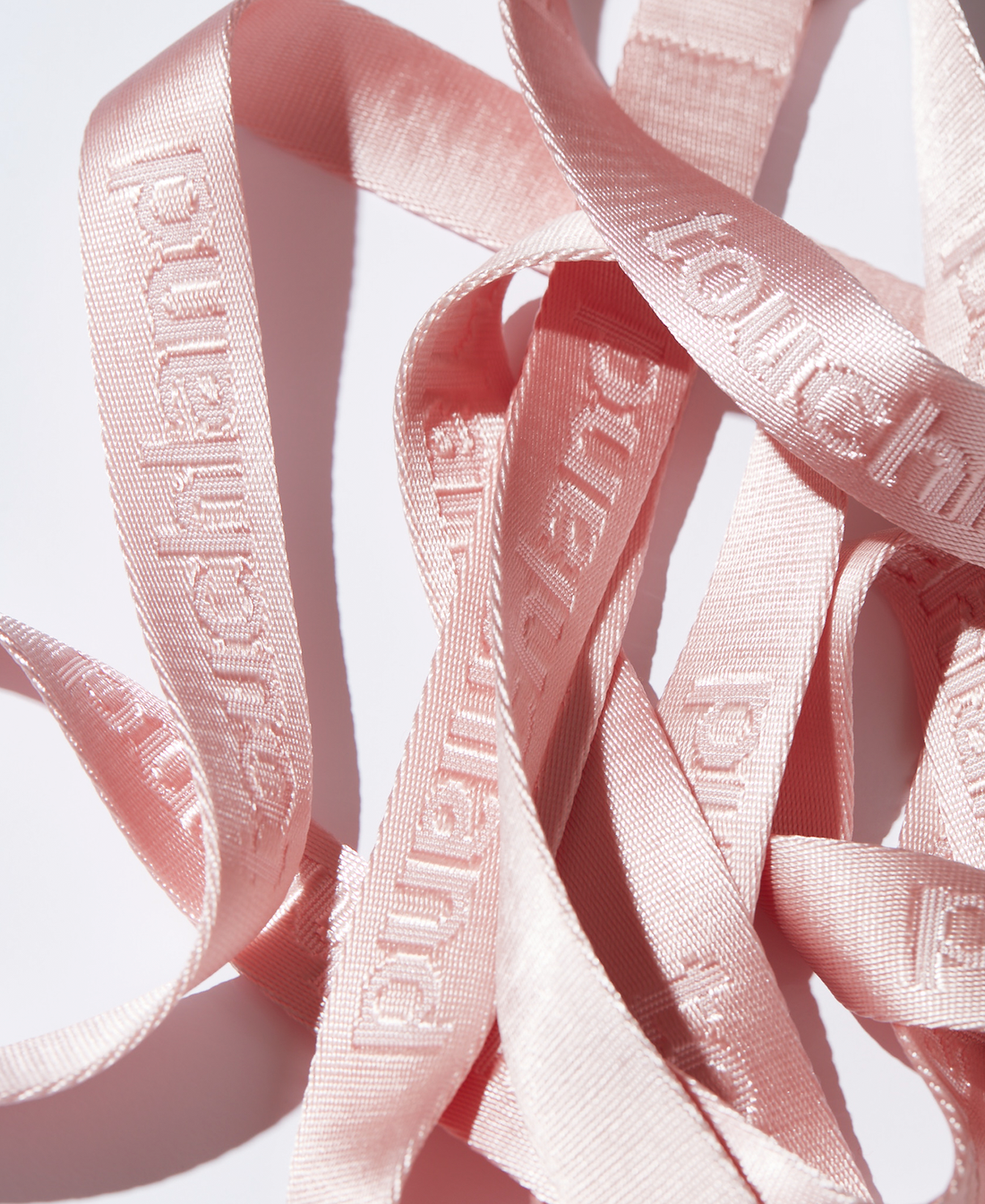 Several pink lanyards zoomed in on white background