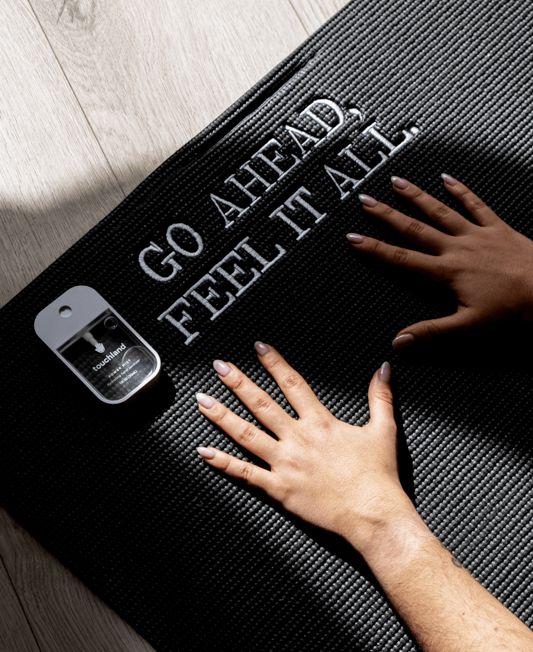 A Power Mist laying on a yoga mat that say 'Go Ahead, Feel It All'