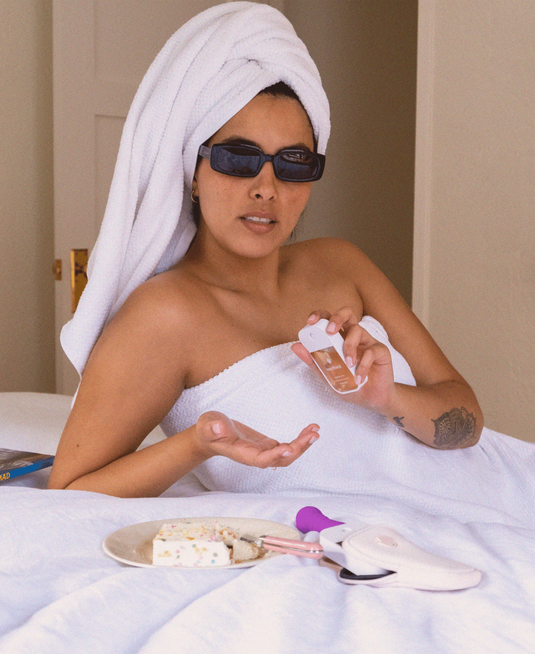 A woman with a towel wrapped around her head using our Velvet Peach Touchland.