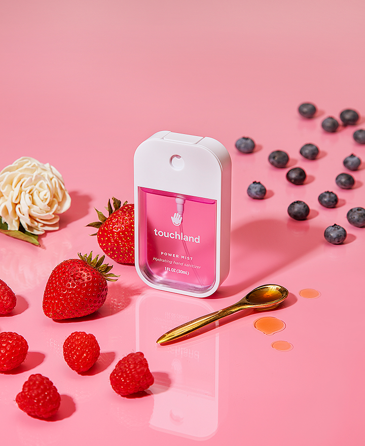 Berry bliss pink hand sanitizer on pink background with berries and gold spoon