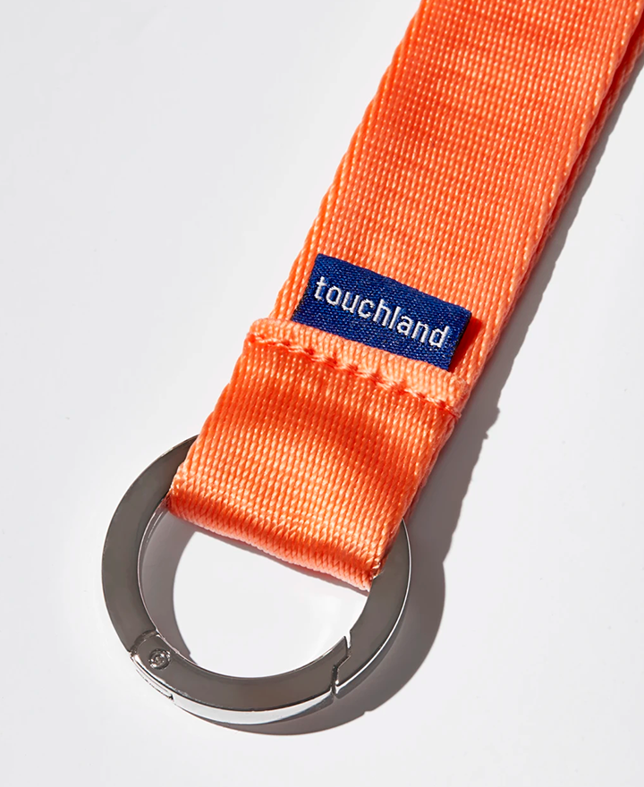 Orange lanyard zoomed in on blue touchland tag and silver keyring