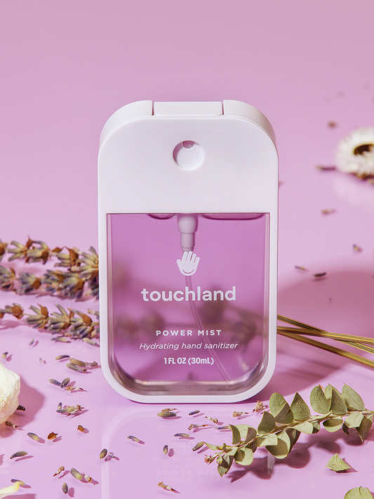 Touchland lavender power mist on purple background surrounded by lavender plant